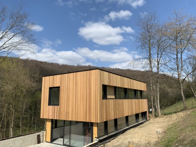 Maison à ossature bois moderne entourée d'arbres