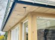 Véranda en bois construite sur une maison en pierre par Florian Huet