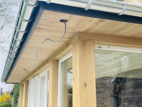 Véranda en bois construite sur une maison en pierre par Florian Huet