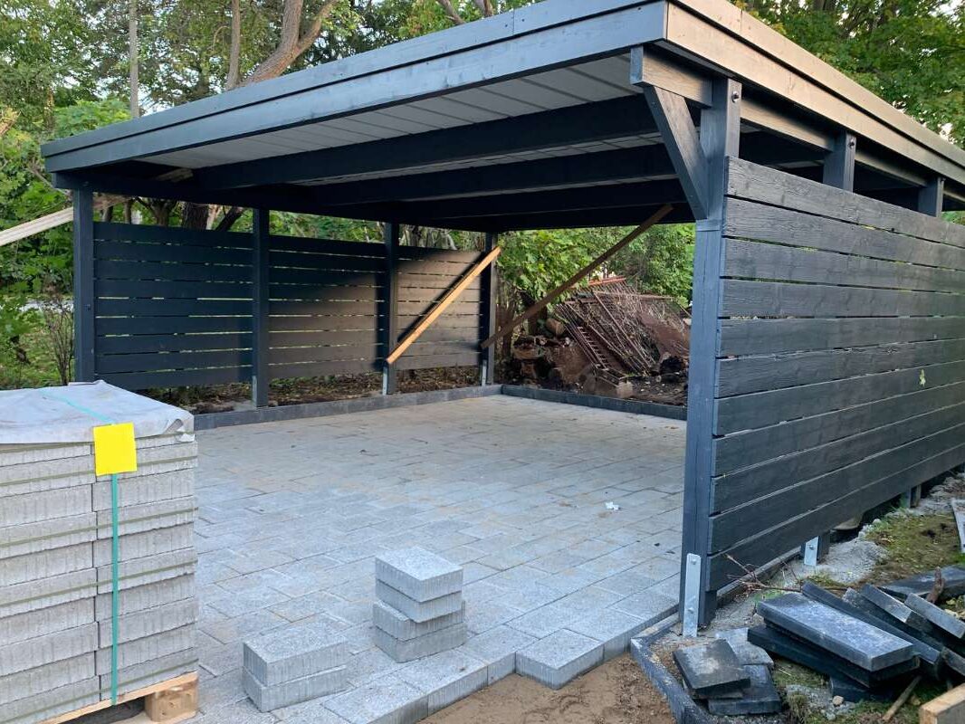 HUET-carport-bois-teinte Carport en bois teinté noir avec un abri intégré en construction