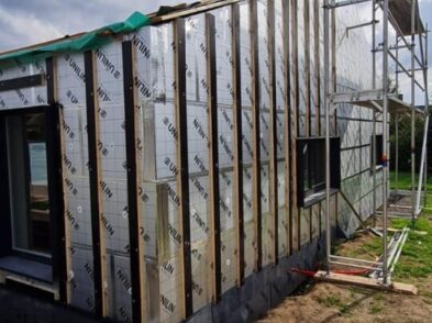 Maison en construction avec un échafaudage adossé à sa droite