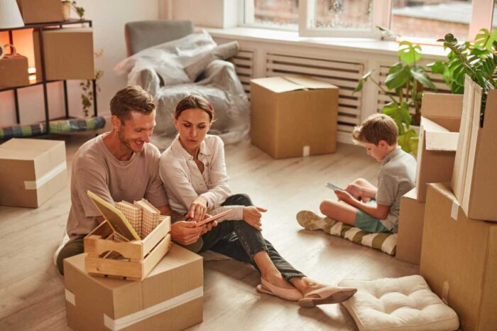 Homme et femme assise sur le sol de leur nouvelle maison neuve en bois